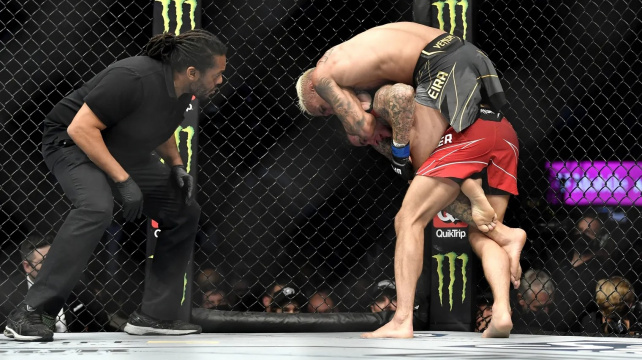 Oliveira uškrtil Poiriera ve stoje a obhájil titul. Po cestě z klece byl však okraden